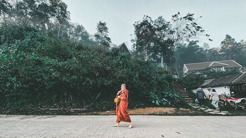 Full length of woman walking against trees