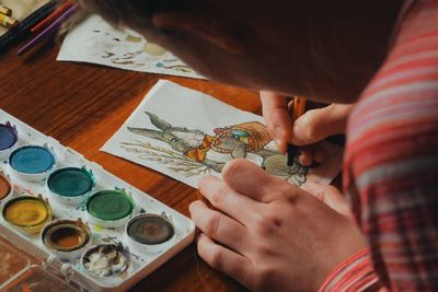 Cropped image of woman painting easter bunny