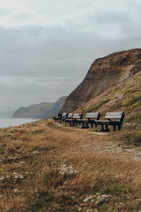 Row of benches along the coastal walk on jurassic coast, a world heritage site in southern england.