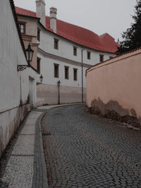 Footpath amidst houses in town against clear sky