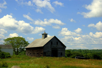 View of field against cloudy sky