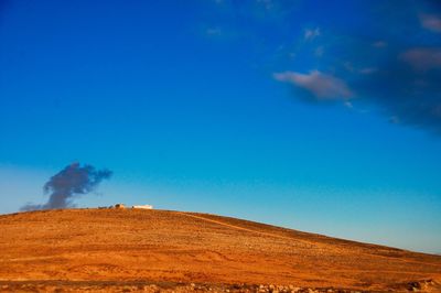 Scenic view of dramatic landscape against blue sky