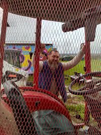 Man standing by chainlink fence