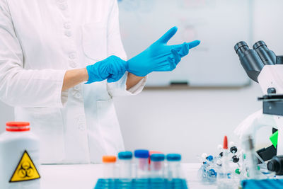 Lab technician putting on protective gloves. laboratory safety equipment, hand protection.