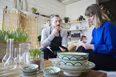 Male and female partners discussing over merchandise at store