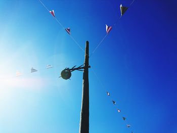 Low angle view of birds flying against clear blue sky