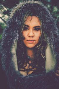 Close-up portrait of young woman wearing fur coat