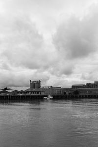 River by buildings against sky