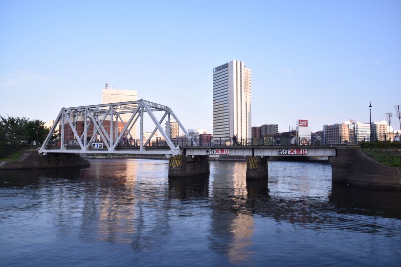 architecture, built structure, water, clear sky, connection, river, building exterior, bridge - man made structure, waterfront, reflection, city, copy space, blue, engineering, bridge, capital cities, low angle view, travel destinations, no people, day