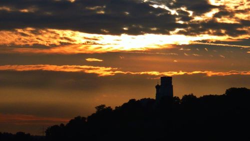 Silhouette of building against dramatic sky