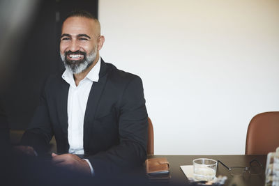 Smiling confident lawyer sitting at conference table in board room