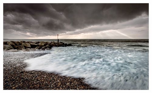 Scenic view of sea against storm clouds