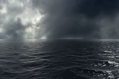 Scenic view of sea against storm clouds