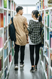 Rear view of women standing on book