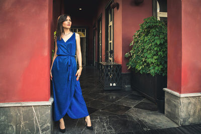 Young woman standing against wall