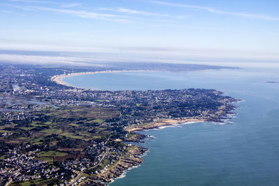 Aerial view of sea and cityscape against sky