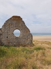 Old ruin on field against sky