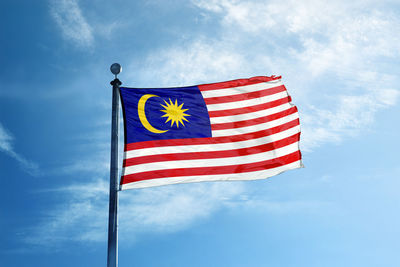 Low angle view of flag against blue sky