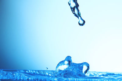 Close-up of water splashing against blue sky