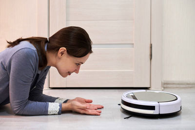 Side view of young woman sitting on table