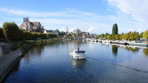 Scenic view of river by buildings against sky