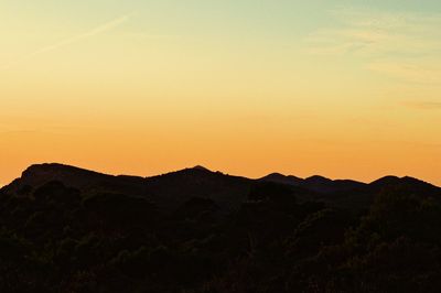 Scenic view of silhouette mountains against sky during sunset