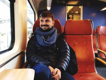 Happy man sitting in train