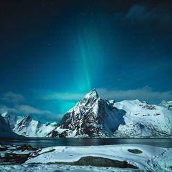 Scenic view of snowcapped mountains against sky at night