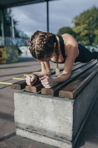 Sporty woman doing plank exercise at park 