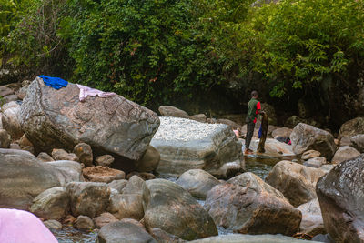 Rear view of people walking on rock