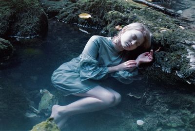 High angle view of woman lying on rock