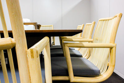 Empty chairs and table against wall at office