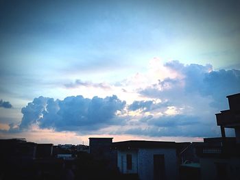 Buildings against cloudy sky at sunset