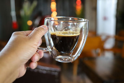 Close-up of hand holding coffee glass