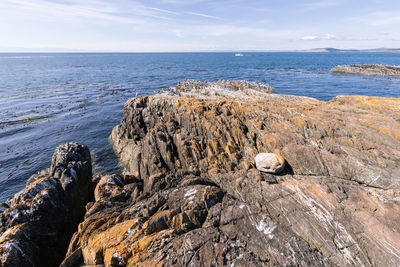 Rock formation on beach against sky