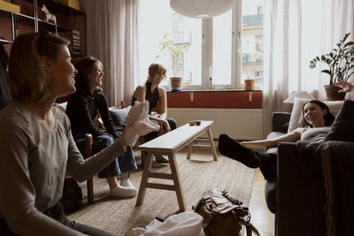 Happy female friends having fun while enjoying during vacation in apartment