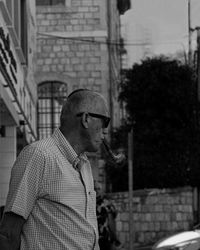 Portrait of young man standing against buildings