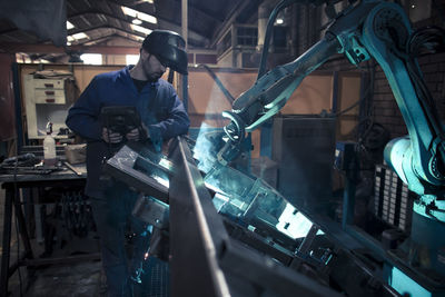 Welder welding metal with robot