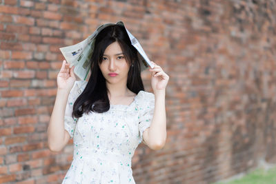 Portrait of woman standing against wall