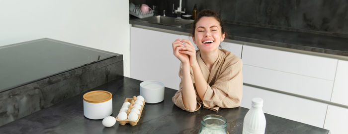 Portrait of young woman drinking coffee at home