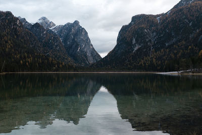 Scenic view of lake by mountains against sky