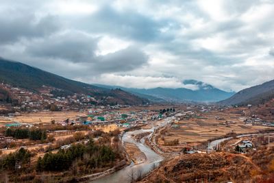Aerial view of townscape and mountains against sky