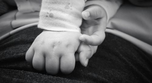 Close-up of father holding baby hand