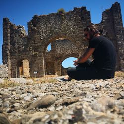 Woman sitting on old ruin
