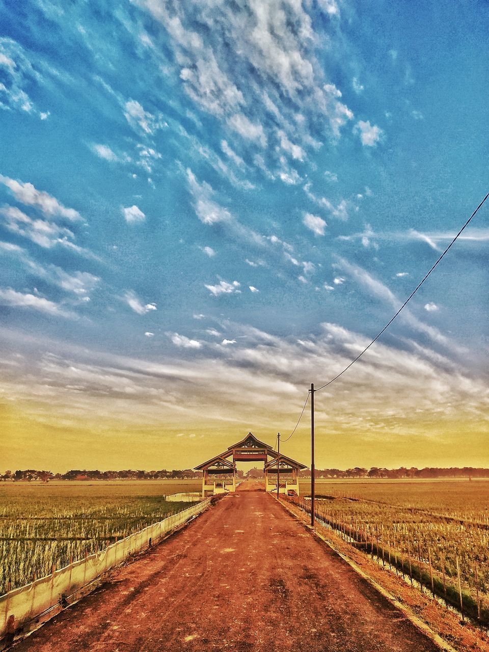 ROAD AMIDST FIELD AGAINST SKY