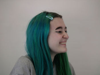 Portrait of beautiful young woman against wall