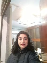 Portrait of smiling young woman standing at home