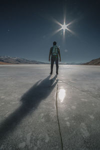 Full length of man on snowy field against sky during winter