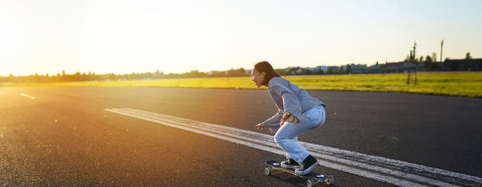 Rear view of woman walking on road