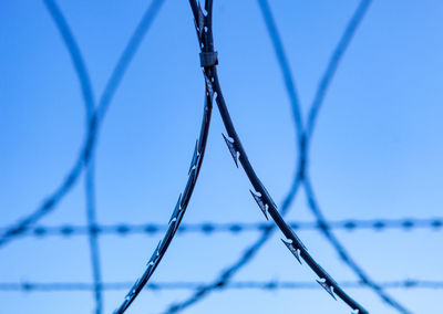 Close-up of barbed wire against sky